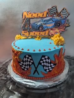 a birthday cake decorated with racing cars and flames