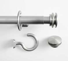 a metal curtain rod with two hooks and a hook on the end, next to a door knob