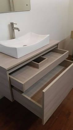 a bathroom with a sink, mirror and wooden flooring in the middle of it