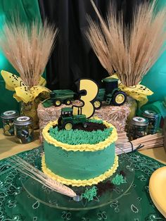 a tractor themed birthday cake is displayed on a table with green and yellow decorating