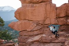 a man sitting on top of a rock formation