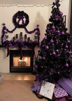 a decorated christmas tree in front of a fireplace with purple decorations and presents on the mantle