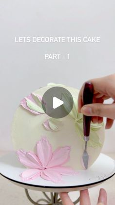 someone is decorating a cake with pink flowers on it and the words let's decorate this cake part - 1