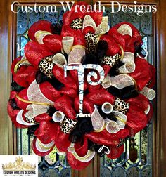 a red and black mesh wreath with the letter t on it's front door