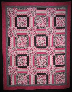 a pink and black quilt with squares on it