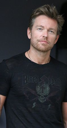 a man wearing a black shirt with a skull on it