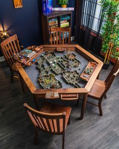 a table that has some wooden chairs around it with lots of items on top of it