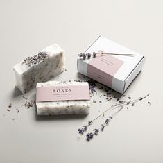 three soap bars sitting next to each other on top of a white table with lavender flowers