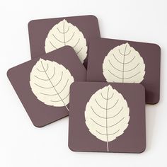 four coasters with white leaves on them