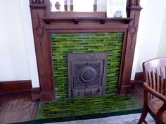 an old fireplace with green tiles in a room