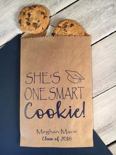 there is a cookie bag with two chocolate chip cookies in it that says she's one smart cookie