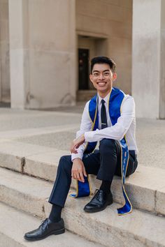 a man sitting on steps wearing a blue vest and tie