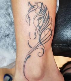 a woman's foot with a horse tattoo on the side of her leg,