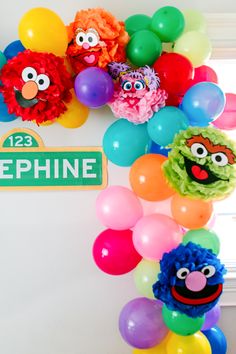 the sesame street sign is surrounded by balloons and decorations for an elmo sesame birthday party