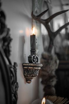 a candle is lit in front of some antlers