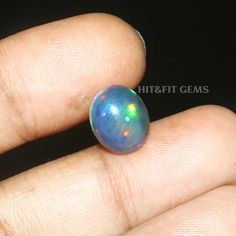 a person's hand holding an opalite ring