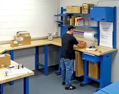 a man standing in front of a blue work bench