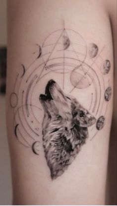 a tattoo with a wolf on it's arm and planets in the sky behind it