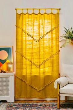 a living room with a white couch and yellow curtains