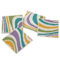 three coasters with colorful stripes on them