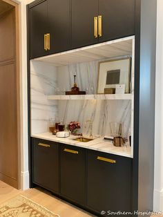 a kitchen with marble counter tops and black cabinets