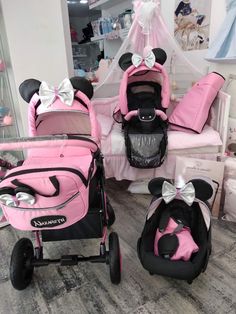 two baby strollers with minnie mouse ears on them, one is pink and the other is black