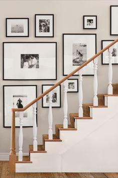 a staircase with pictures on the wall and wooden handrails in front of it