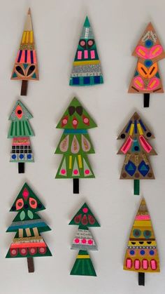 colorful paper christmas trees are displayed on the wall