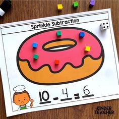 a pink donut on top of a piece of paper next to colored pegs