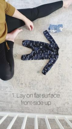 a woman sitting on the floor next to her leggings and an object that says lay on flat surface front - side up