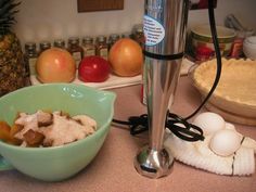 a blender sitting on top of a counter next to bowls filled with fruit and other ingredients