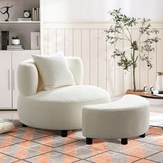 a white chair and ottoman in a living room with orange rugs on the floor