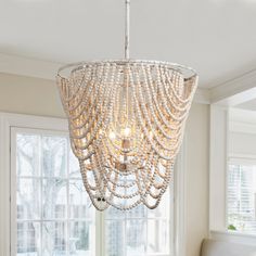 a chandelier hanging from the ceiling in a room with white walls and windows