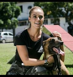 a woman sitting in the grass with her dog