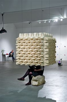 a woman sitting on top of a rock covered in blocks of wood