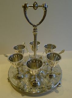 a silver plate topped with cups and saucers