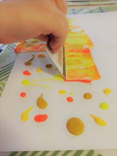 a child is painting with acrylic paint on paper