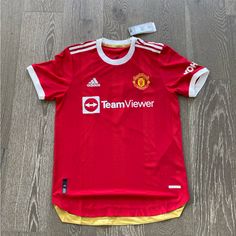 This Nice Jersey From Adidas Features White Ribbing, Rounded Hem And Recycled Material Construction. New With Tags, But Has Some Holes/Marks On The Back Size Medium Fitted Red Adidas Top, Red Fitted Adidas Top, Affordable Red Jersey T-shirt, Red Adidas Short Sleeve T-shirt, Affordable Red Sports T-shirt, Red Adidas, Adidas Men, Manchester United, Manchester