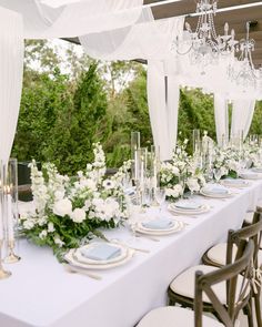 a long table with white flowers and place settings