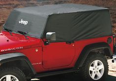 a red jeep with a black cover on it