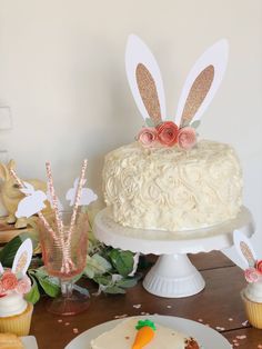 there is a cake with bunny ears on it and some cupcakes next to it