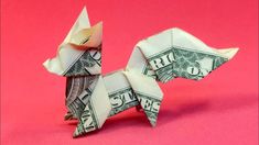 an origami dog made out of one dollar bill on a pink background,