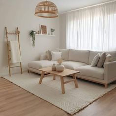 a living room with a white couch and wooden coffee table in front of a window