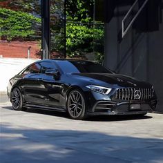 a black mercedes cla parked in front of a building