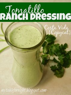 a glass jar filled with green liquid next to cilantro