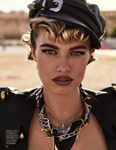 a close up of a person wearing a hat and necklace with jewelry on her neck