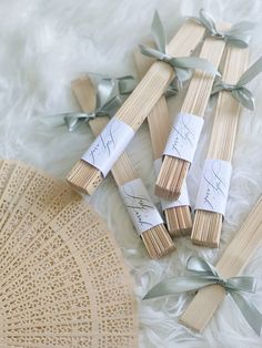 several matchesticks with writing on them sitting next to a fan and lace doily