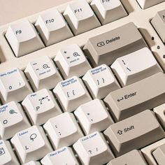 a close up view of a computer keyboard with white keys and blue lettering on it