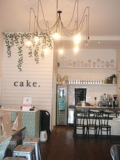 the inside of a cake shop with lights hanging from the ceiling