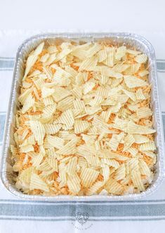 a casserole dish filled with cheesy chips on top of a blue and white table cloth